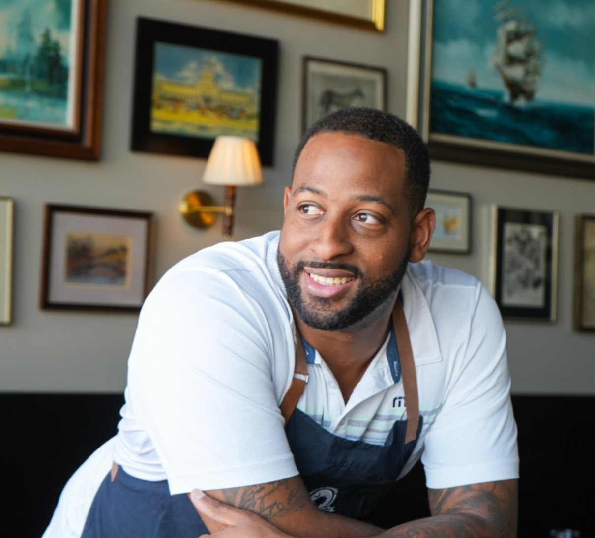 Smiling restaurant team member in an apron at a Ripple-backed Lowcountry restaurant