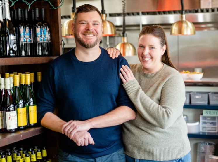Restaurant owners smiling together inside their Lowcountry restaurant