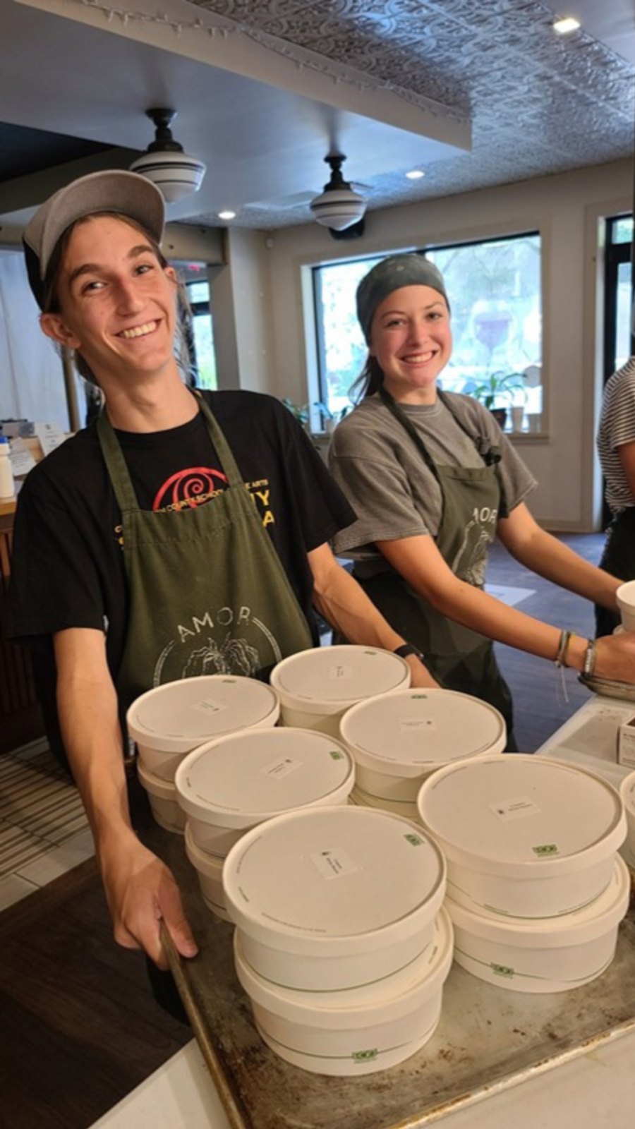 Restaurant staff in aprons packing meals in the kitchen